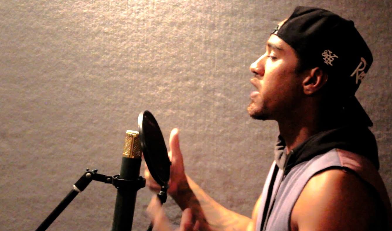 Jordan Oliver recording music on microphone.